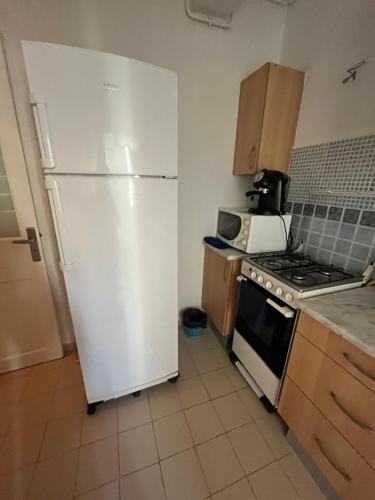 a kitchen with a white refrigerator and a stove at Appartement S1 Jardins l aouina in Tunis