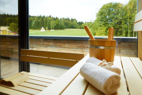 a table with a towel and a cup and a window at Wellness & Naturresort Reischlhof in Wegscheid