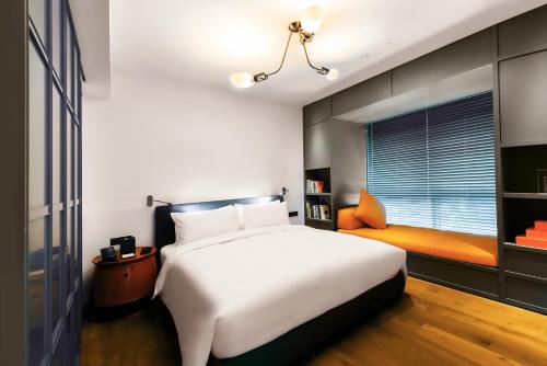 a bedroom with a large white bed and a window at Hotel Kapok Shenzhen HouHai (Close to Shenzhen Bay) in Shenzhen