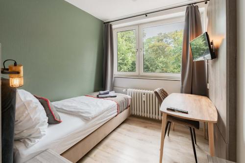 um pequeno quarto com uma cama e uma janela em Hotel Enger Hof em Düsseldorf