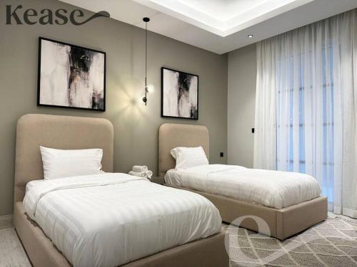 two beds in a bedroom with two bedsskirts at Kease King Salman T-6 Royal Touch GZ61 in Riyadh