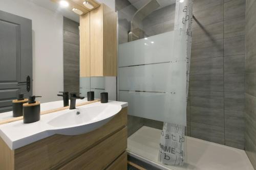 La salle de bains est pourvue d'un lavabo et d'une douche. dans l'établissement Le Cotentin - Joli appt 2 chambres à Carentan, à Auvers
