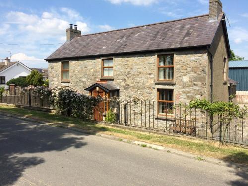 an old stone house with a fence at Grove Fort Self Catering Farmhouse in Finnis
