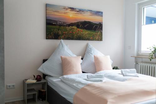 a bedroom with two beds and a painting on the wall at gemütlich und modern - ruhig und zentral in Hünfeld