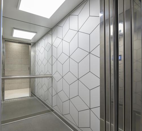 a walk in shower in a bathroom with white tiles at ''THE 58 PROJECT'' in Alexandroupoli