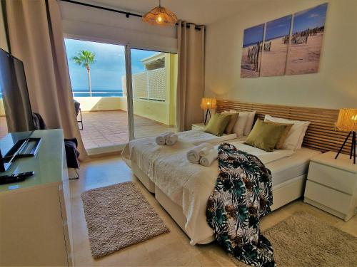 a bedroom with a bed with a view of the ocean at Apartments Bermuda Beach in Estepona