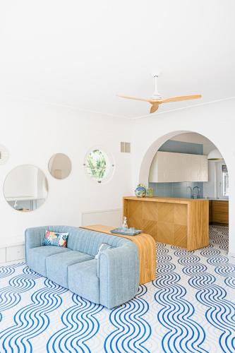 a living room with a blue couch and a kitchen at Acquachiara Seaside Luxury Villa in Amalfi Coast in Maiori