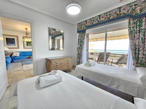 a hotel room with two beds and a balcony at Apartamento Las Terrazas in La Herradura