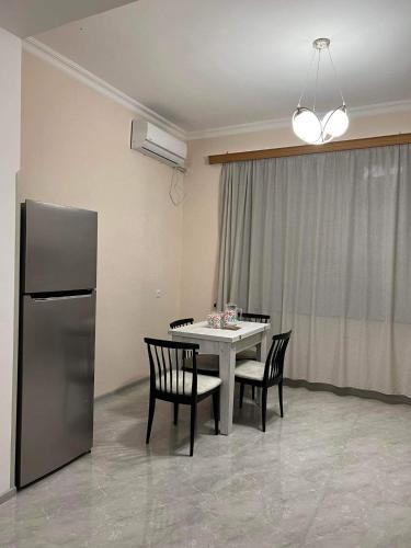 een eetkamer met een tafel en stoelen en een koelkast bij Apartment Tskaltubo in Tsqaltubo