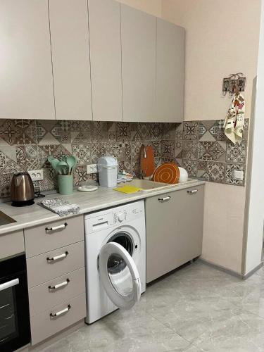 een keuken met een wasmachine bij Apartment Tskaltubo in Tsqaltubo