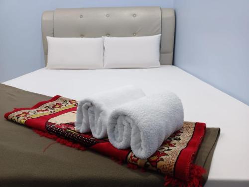 a bed with white blankets and pillows on it at SERI IBAI DAMAI in Kuala Terengganu