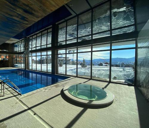 a large building with a swimming pool and a large window at Matt & Sarah’s Cozy Family Duplex in Gudauri