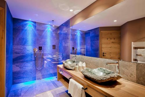 a large bathroom with a sink and a shower at Cyprianerhof Dolomit Resort in Tires