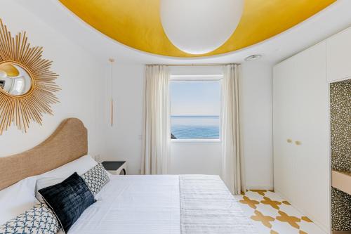 a bedroom with a large bed with a large window at Acquachiara Seaside Luxury Villa in Amalfi Coast in Maiori
