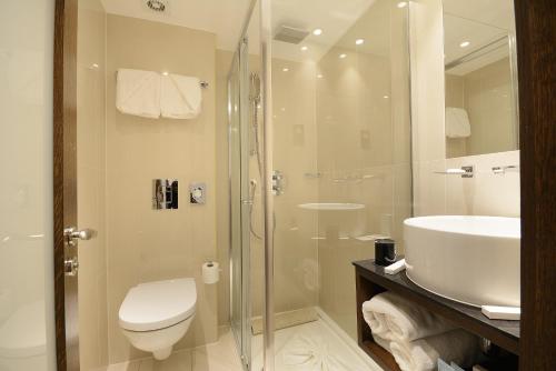 a bathroom with a shower and a toilet and a sink at Park Grand Paddington Court in London