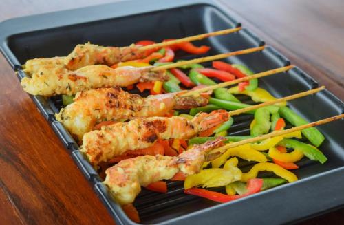 a tray of food with chicken skewers and vegetables at Ibex Resorts, Coonoor Leewood in Coonoor
