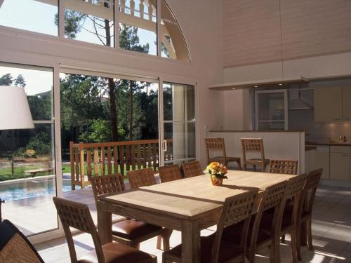 une cuisine et une salle à manger avec une table et des chaises en bois dans l'établissement Villa in Lacanau-Océan with Private Pool, à Lacanau
