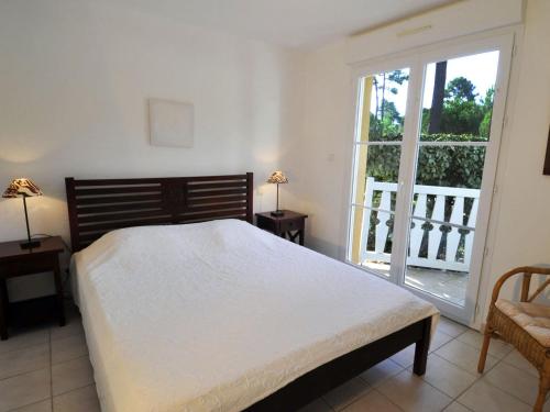 une chambre avec un lit et une grande fenêtre dans l'établissement Villa near Lacanau-Océan with Private Pool, à Lacanau