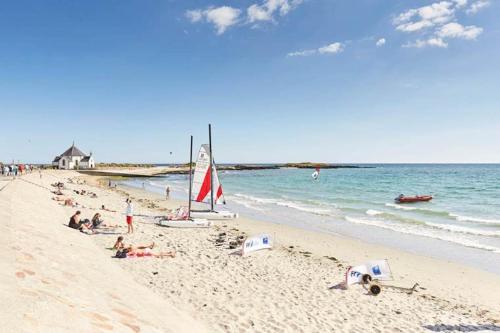 uma praia com pessoas deitadas na areia e no oceano em Superbe Villa au Calme avec Piscine Chauffée à 5 min de la Plage de Penvins em Sarzeau