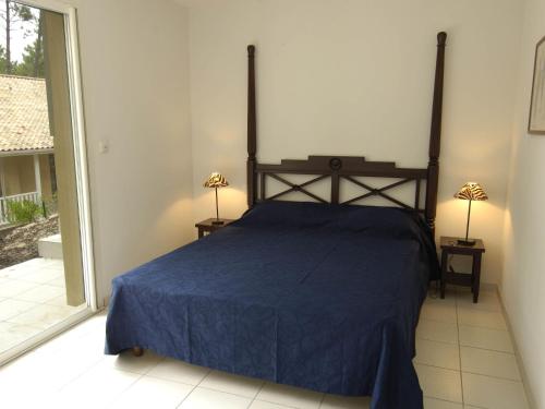 une chambre avec un lit avec un couvre-lit bleu dans l'établissement Villa in Aquitaine with Private Pool & Beach, à Lacanau-Océan