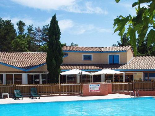 un complexe avec une piscine et un bâtiment dans l'établissement Provencal-style maisonette with communal pool, à Gaujac