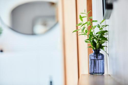 a blue vase with a plant sitting on a window sill at Cottage on The Croft in Hungerford