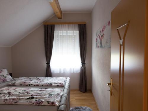 a small bedroom with a bed and a window at Cosy apartment in Arnoldstein with parking lot in Arnoldstein
