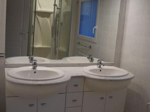 une salle de bain avec deux lavabos et un grand miroir dans l'établissement Villa near Lacanau-Océan with Private Pool, à Lacanau-Océan