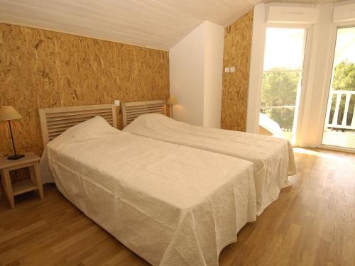 une chambre avec un lit et une grande fenêtre dans l'établissement Villa near Lacanau-Océan with Private Pool, à Lacanau-Océan