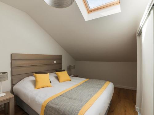 une chambre avec un grand lit avec des oreillers jaunes dans l'établissement Apartment in Biscarosse near Sandy Beach, à Biscarrosse