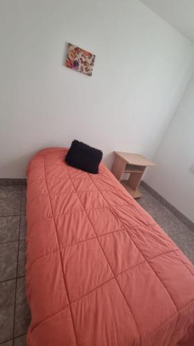 a bed in a room with a red blanket at Casa de 3 ambientes in Río Grande
