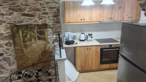 a kitchen with wooden cabinets and a stone wall at Olympus in Olýmpoi