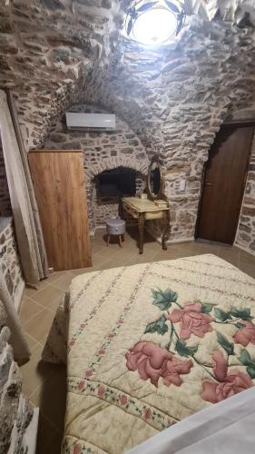 a bedroom with a bed in a stone room at Olympus in Olýmpoi