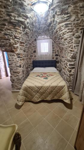 a bedroom with a bed in a stone wall at Olympus in Olýmpoi