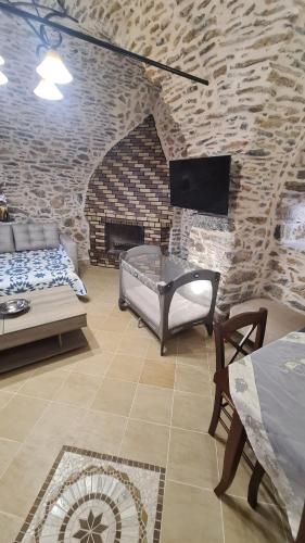 a living room with a bed and a brick wall at Olympus in Olýmpoi
