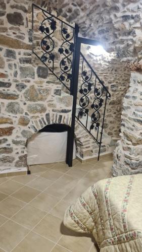 a room with a stone wall with a fireplace at Olympus in Olýmpoi