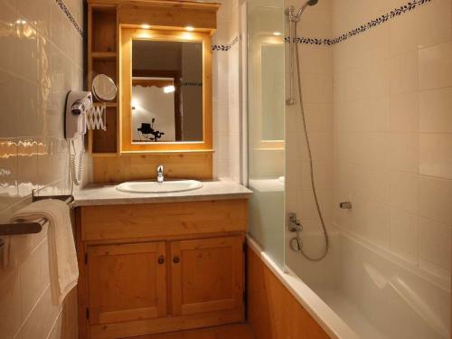 a bathroom with a sink and a tub and a mirror at Apartment on the slopes in the big ski area Grandes Rousses in Oz