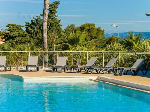 une piscine avec des chaises longues et une piscine dans l'établissement Apartment in Le Brusc near Sandy Beach, à Six-Fours-les-Plages