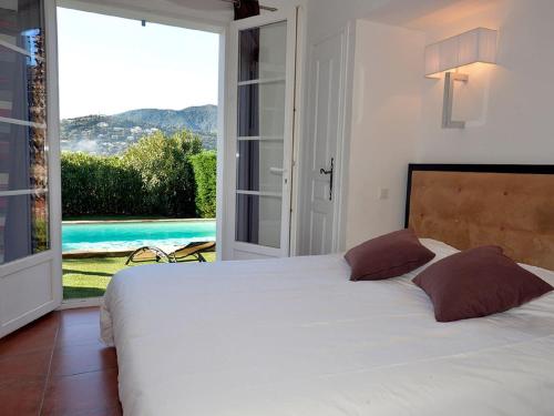 une chambre avec un lit avec vue sur une piscine dans l'établissement Villa in Cavalaire with Private Pool, à Cavalaire-sur-Mer