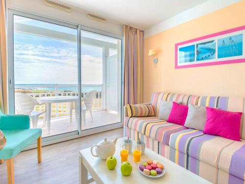 un salon avec un canapé et une vue sur l'océan dans l'établissement Apartment in France near Scenic Coast, à Château-dʼOlonne