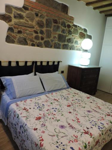 a bedroom with a bed with a stone wall at La Casa di Olga in Radicofani