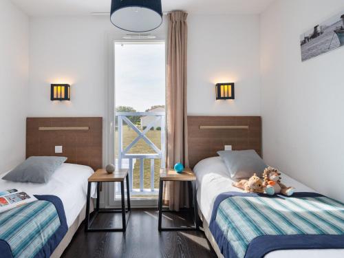 2 camas en una habitación con ventana en Well-kept apartment, with dishwasher, 7 km from the beach, en Saint-Hilaire-de-Talmont