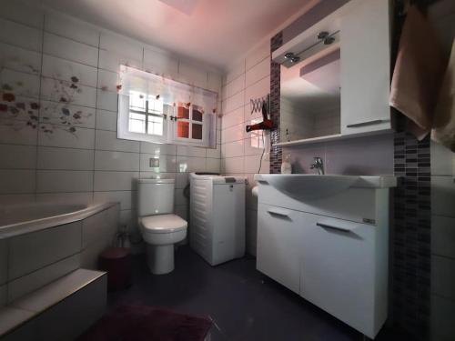 a bathroom with a sink and a toilet and a tub at Casa Olena in Nea Potidaea