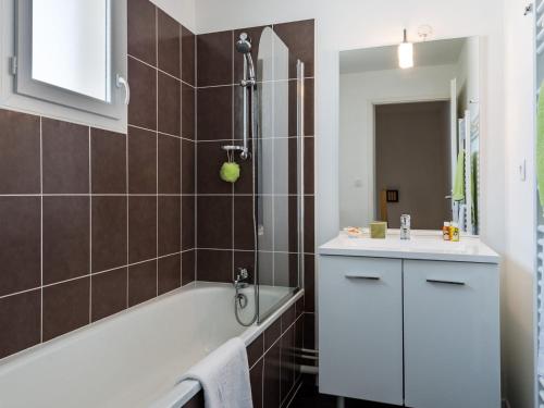une salle de bain avec une baignoire et un lavabo dans l'établissement Seaside Duplex w Heated Pool, à Saint-Hilaire-de-Talmont
