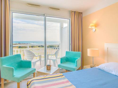 Cette chambre d'hôtel dispose d'un lit, de chaises et d'un balcon. dans l'établissement Apartment in France near Scenic Coastline, à Château-dʼOlonne