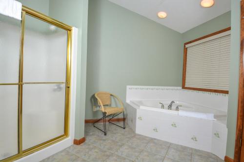 a bathroom with a bath tub and a chair at Tranquility in McHenry