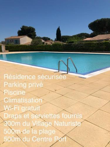 un panneau en face d'une piscine dans l'établissement Appartement JADE dans résidence proche Tennis/ centre naturiste, au Cap d'Agde