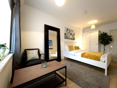 Pass the Keys Cosy Studio Flat Close To Bexleyheath Centre في بيكسليهيث: غرفة نوم بسرير وكرسي وطاولة