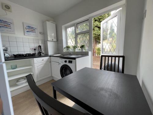 Una cocina con una mesa, una estufa y un fregadero. en Pass the Keys Cosy Studio Flat Close To Bexleyheath Centre, en Bexleyheath