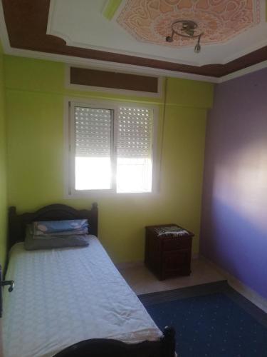a bedroom with a bed and a window at Appartement Boekidan/Al houceima 